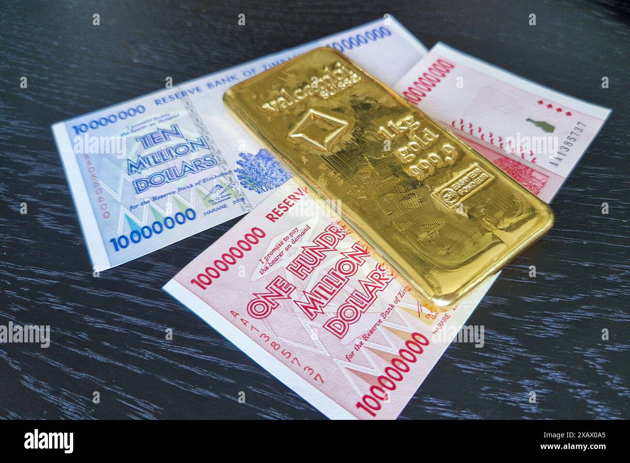 Stockholm, Schweden - 15. Mai 2024: Einhundert Millionen Dollar und zehn Millionen Dollar Banknoten von Simbabwe mit Goldbarren. Stockfoto