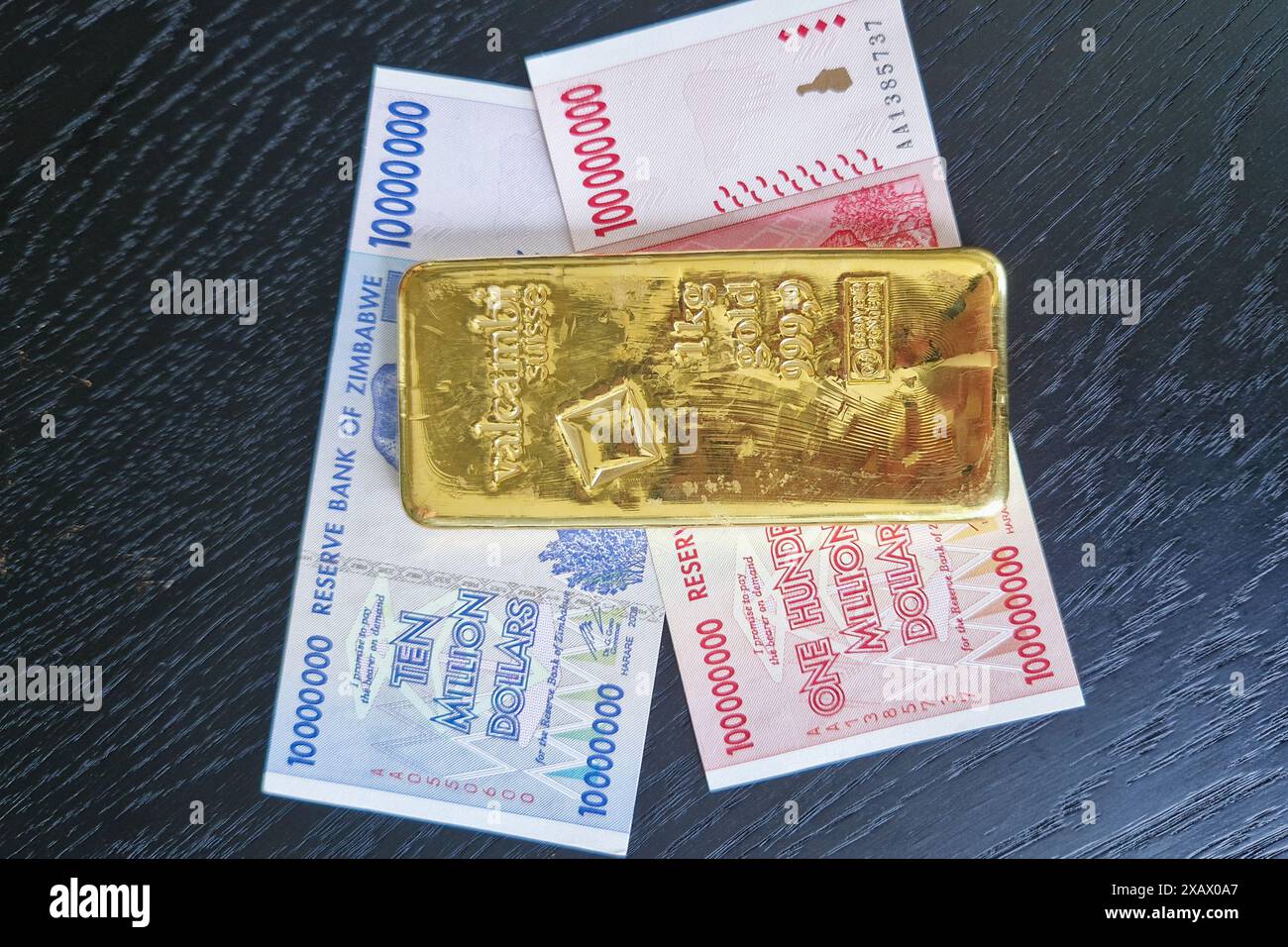Stockholm, Schweden - 15. Mai 2024: Einhundert Millionen Dollar und zehn Millionen Dollar Banknoten von Simbabwe mit Goldbarren. Stockfoto