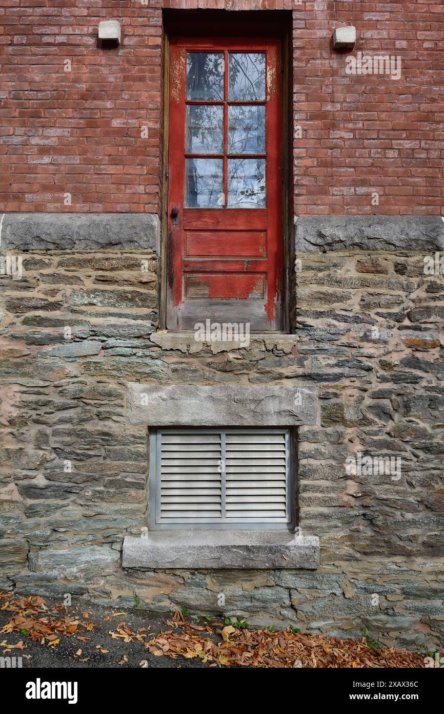 Passen Sie auf Ihren Schritt auf, fehlende Treppe, Baufehler, Tür hoch über dem Boden, rote Tür ins Nirgendwo Stockfoto