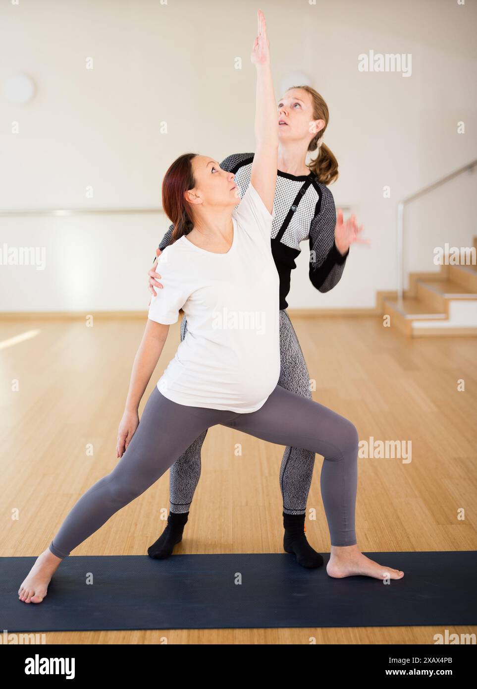 Frau, die Yoga mit dem Lehrer macht Stockfoto