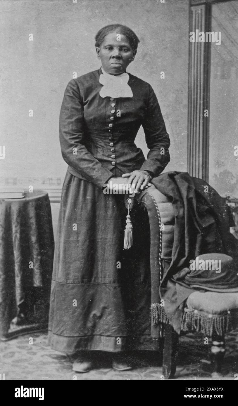 Ein schwarz-weißes Porträt von Harriet Tubman, einer prominenten Abolitionistin und Dirigentin der Underground Railroad, aufgenommen im späten 19. Jahrhundert. Sie ist formell gekleidet und sitzt mit gefalteten Händen auf der Rückseite eines Stuhls. Stockfoto