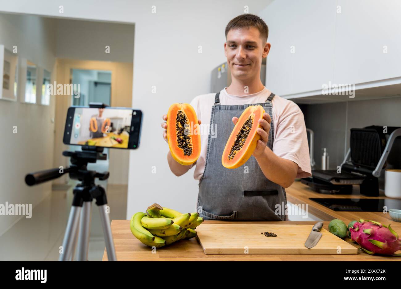 Der Koch sendet live aus dem Workshop, wie man Papaya schneidet und schält Stockfoto