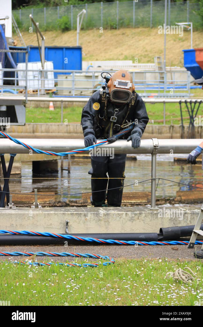 Taucher steigt in den Belüftungsbehälter einer Kläranlage Stockfoto