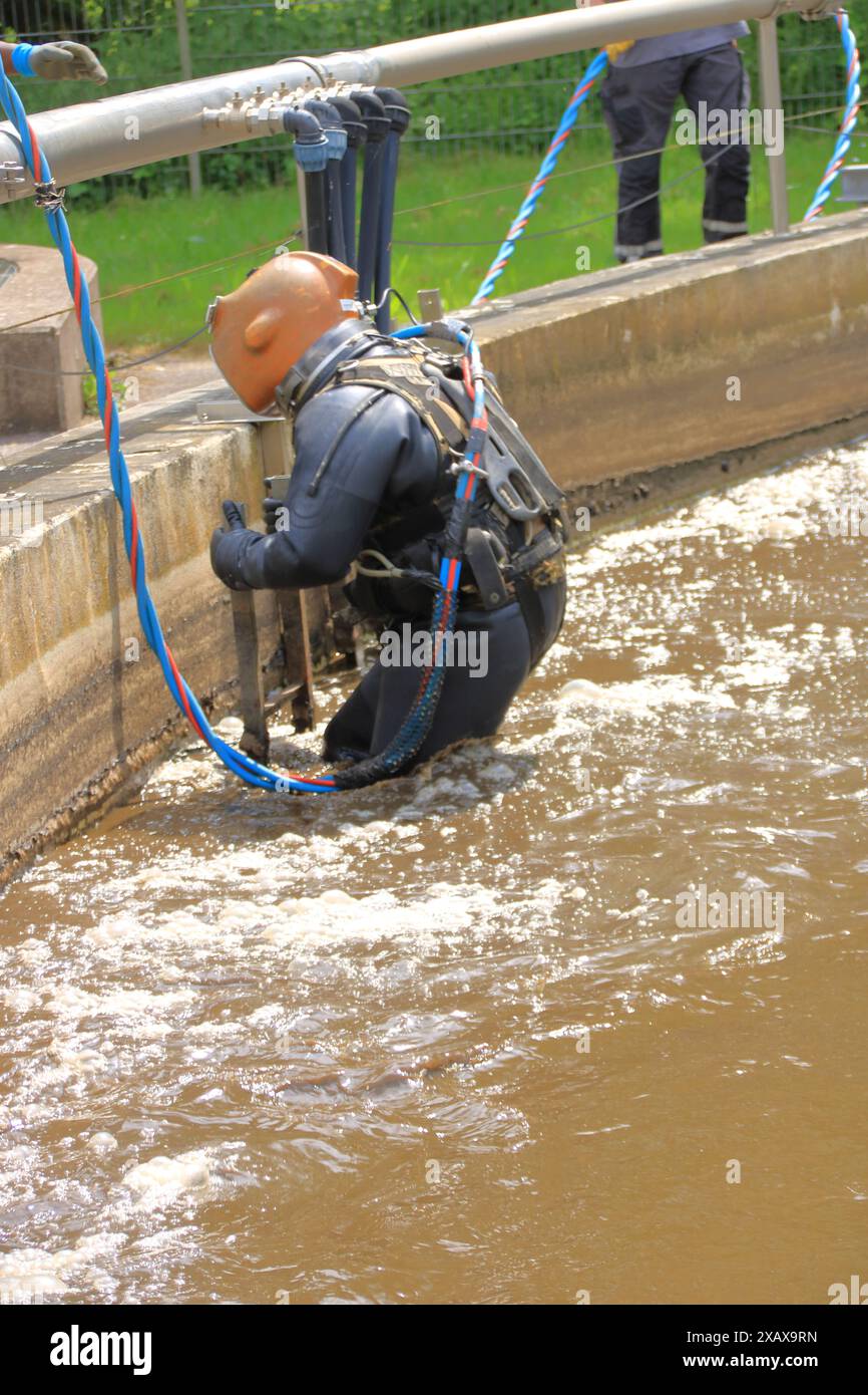 Taucher steigt in den Belüftungsbehälter einer Kläranlage Stockfoto