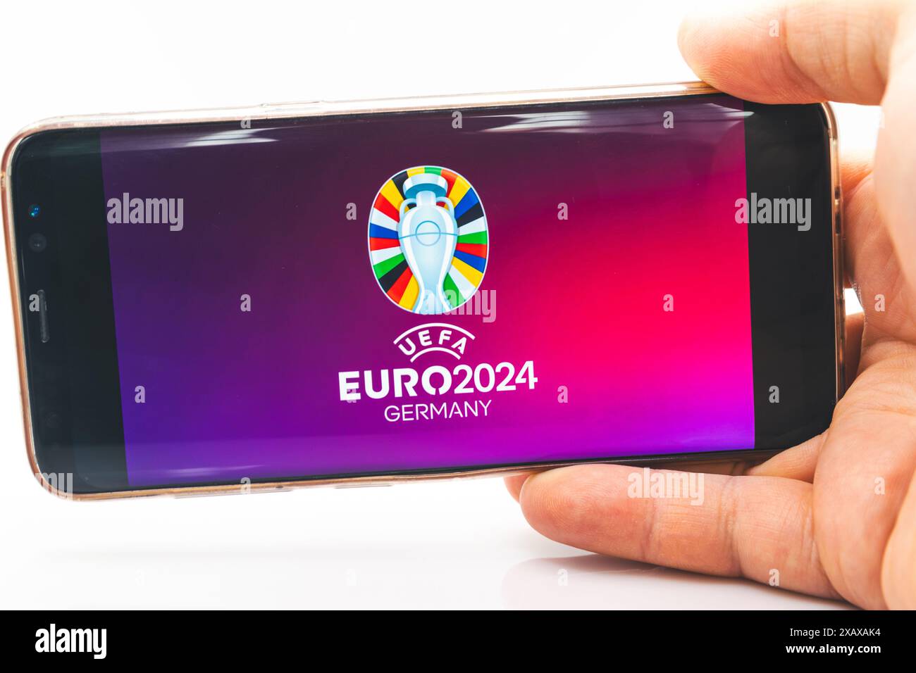 Ein Mann hält ein Smartphone mit dem offiziellen Logo der UEFA-Fußball-Europameisterschaft 2024 auf dem Handy-Bildschirm Stockfoto
