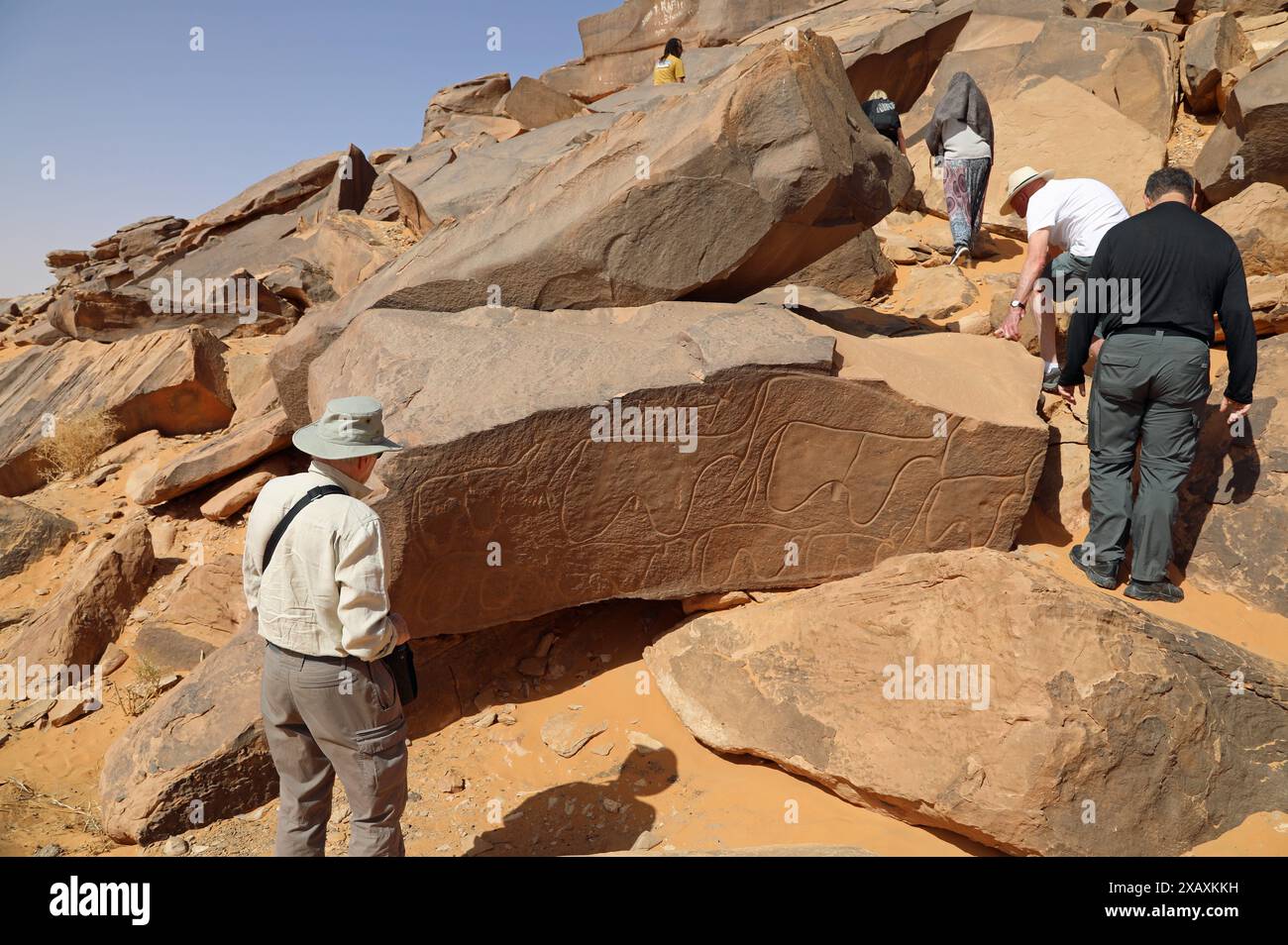 Reisende, die nach den Petroglyphen in Taghit in Westalgerien suchen Stockfoto