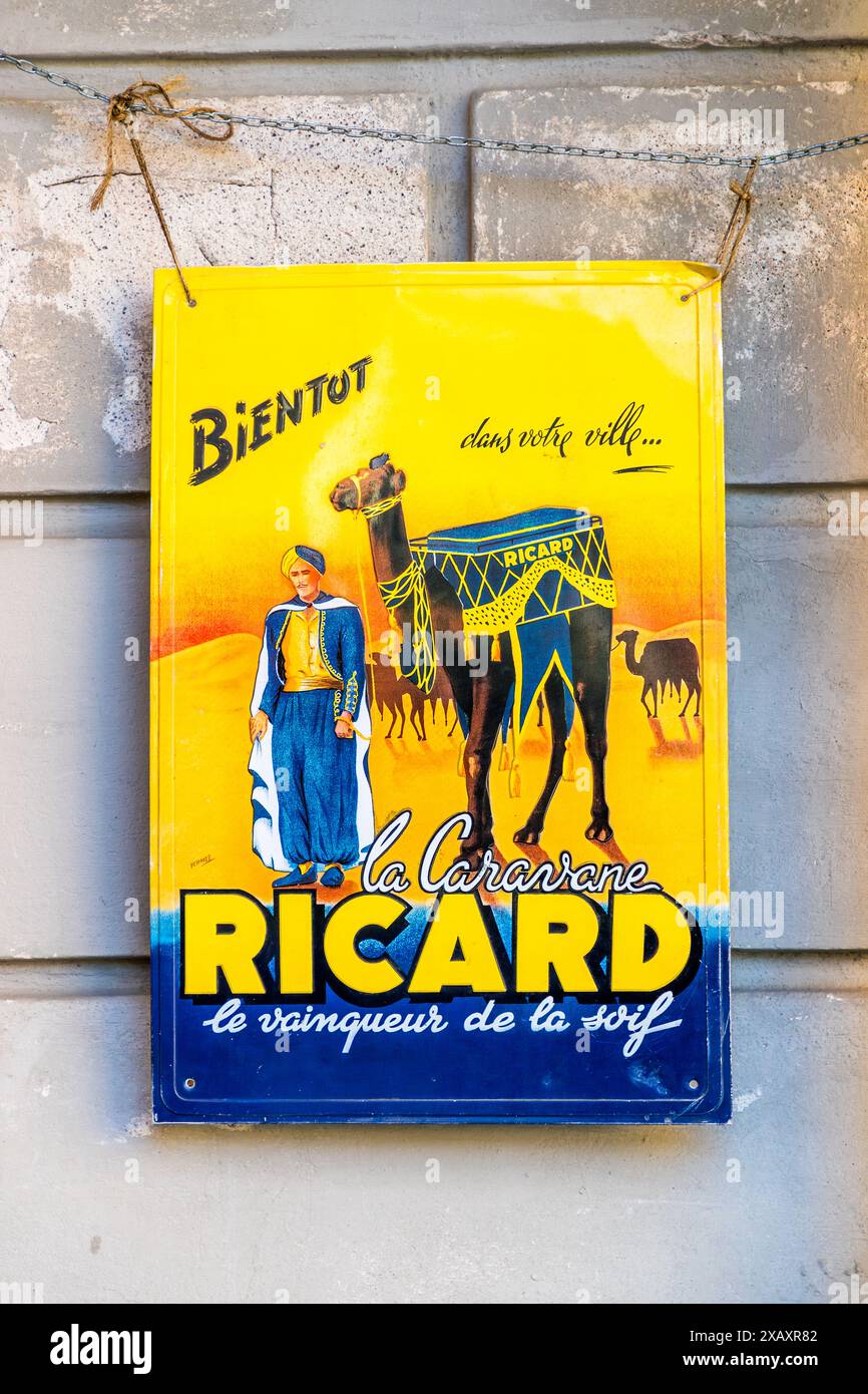 Ein verwittertes Werbeschild für den französischen Anis-Schnaps-Hersteller Ricard hängt an einer abgenutzten Fassade in der Altstadt von Stockholm. "La Caravane" zeigt einen Mann in nahöstlicher Kleidung neben einem beladenen Kamel vor einer Wüstenkulisse, mit dem französischen Slogan "le vainqueur de la soif" (der Besieger des Durstes). Gamla Stan, Stockholm, Schweden. Stockfoto