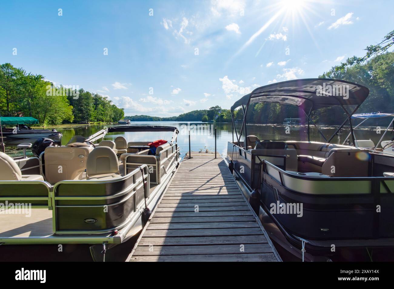 Zwei Pontonboote flankieren an jeder Seite eines Bootsanlegeplatzes auf einem See im Norden von Wisconsin. Stockfoto
