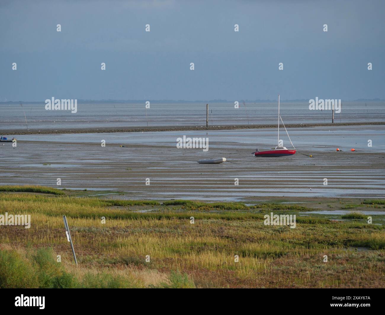 Weite Wattgebiete mit Booten im flachen Wasser und ein ruhiges, friedliches Gefühl, saftig, ostfriesland, deutschland Stockfoto