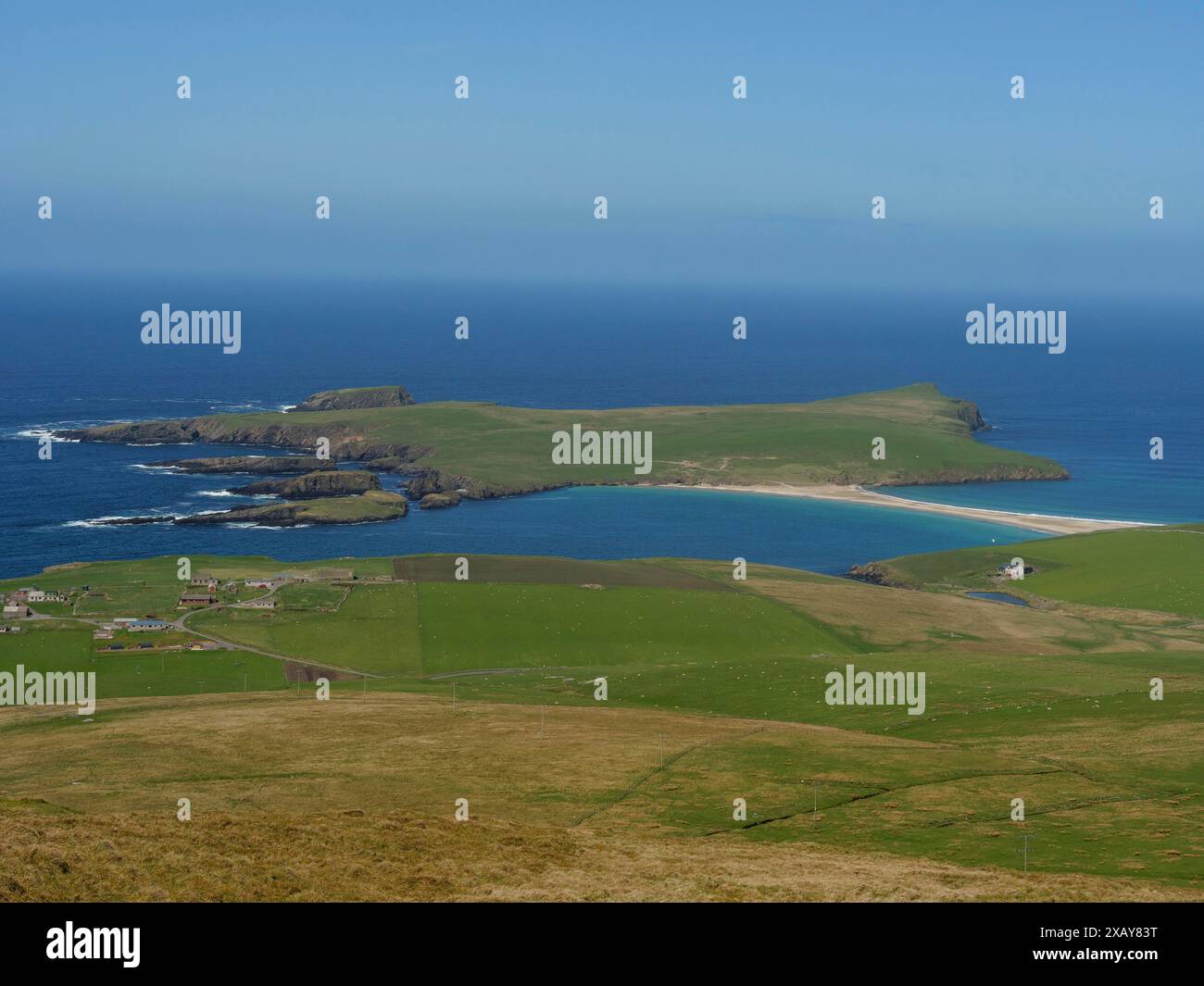 Erhöhte Perspektive auf eine Insel mit einer Küste umgeben von grünem Gras und einem Sandstrand, Lerwick, Shetland, Schottland, Großbritannien Stockfoto