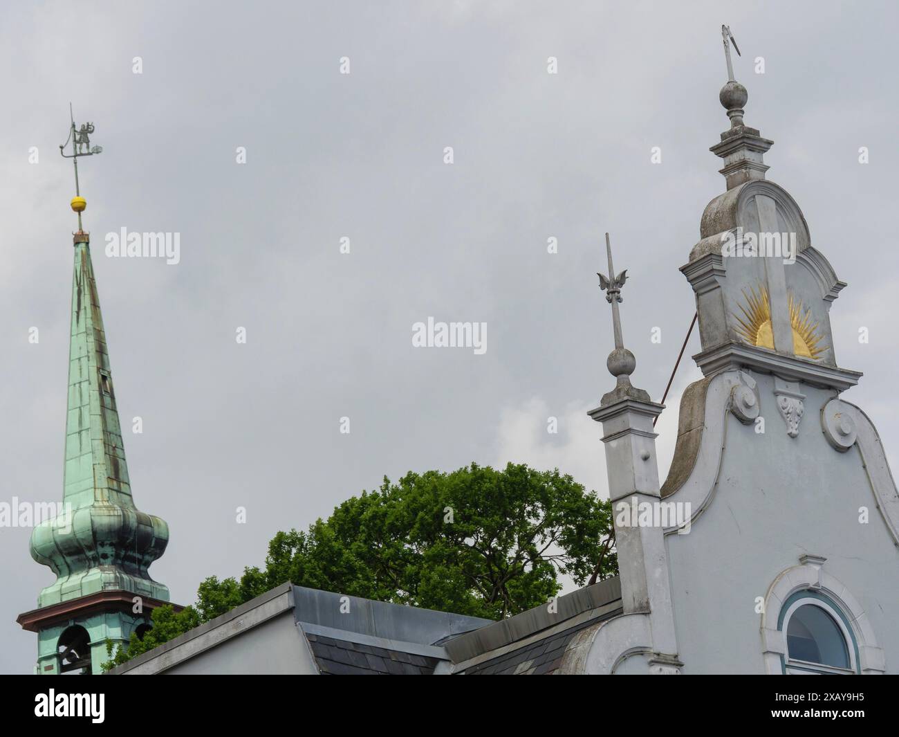 Nahaufnahme einer Kirche mit verzierten Türmen und Wetterfahne vor grauem Himmel, Kappeln, Schleswig-Holstein, Deutschland Stockfoto