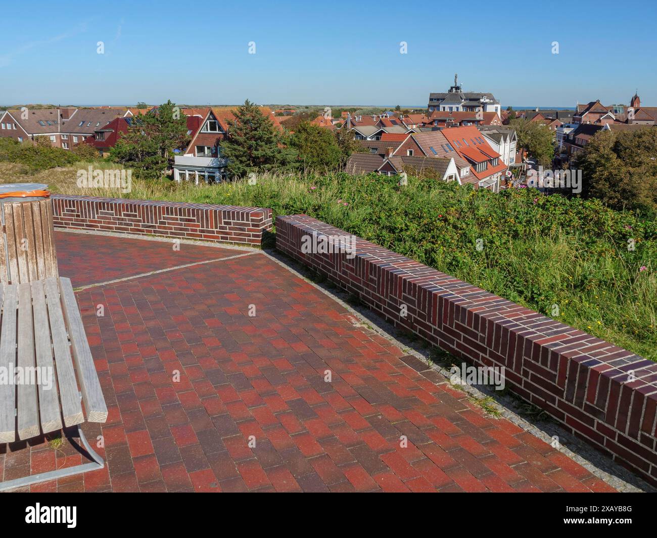 Aussichtspunkt über eine Stadt mit Ziegelboden und Bank unter klarem Himmel, langeoog, deutschland Stockfoto