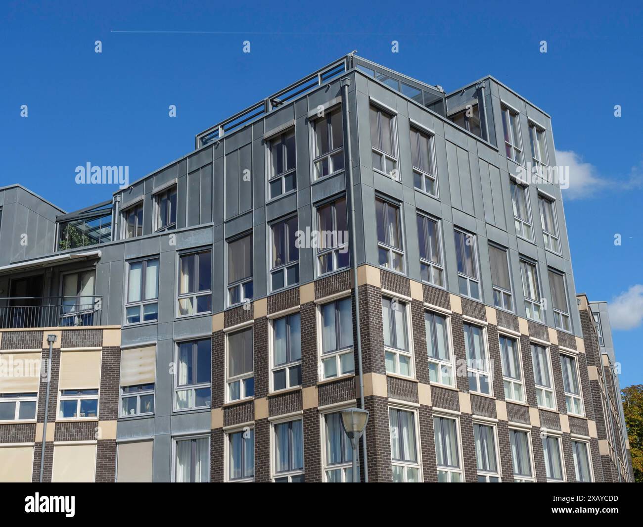 Modernes mehrstöckiges Gebäude mit zahlreichen Fenstern unter klarem blauem Himmel, Doesburg, Niederlande Stockfoto