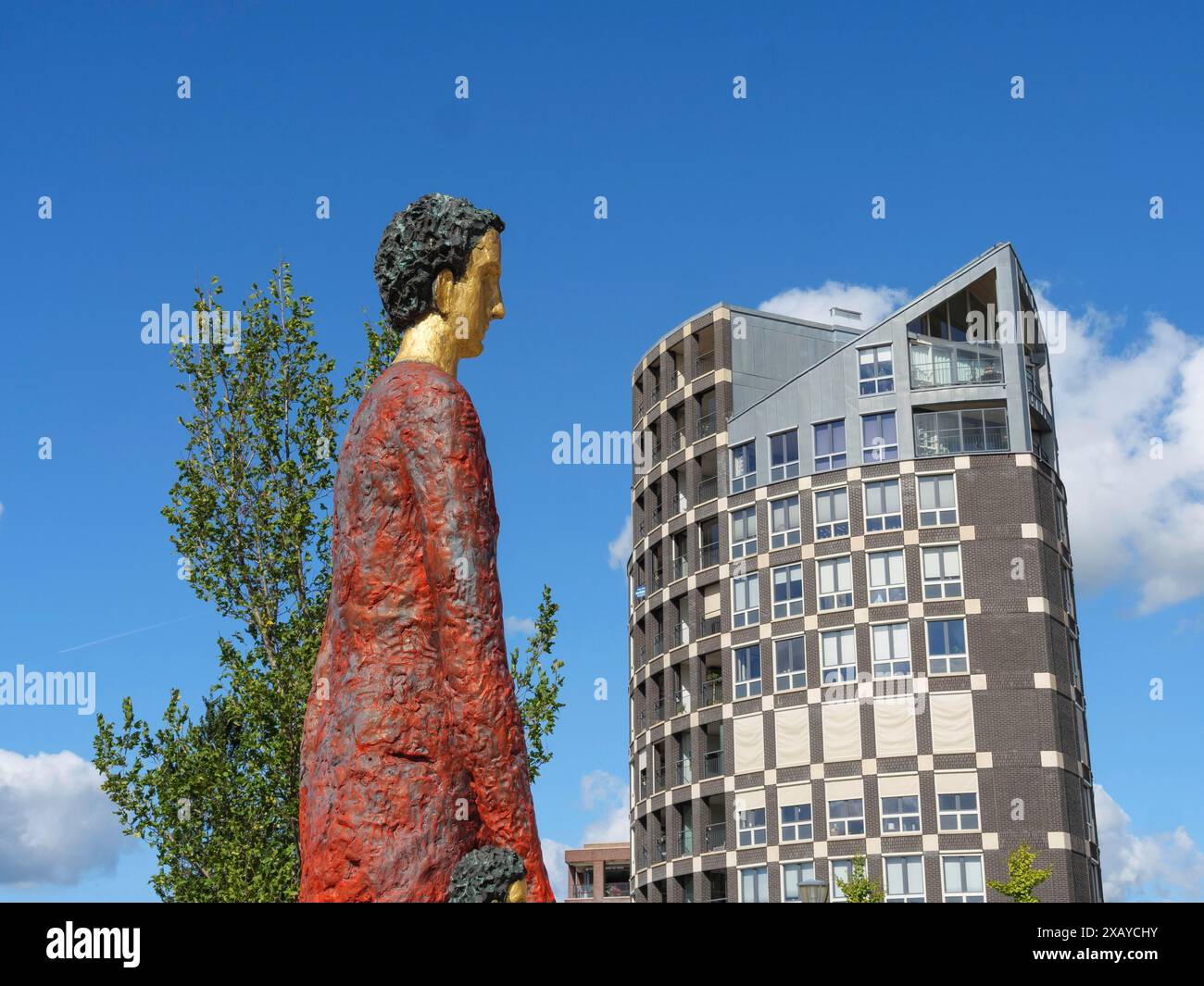 Skulptur einer Person vor einem modernen architektonischen Gebäude unter einem klaren blauen Himmel, Doesburg, Niederlande Stockfoto