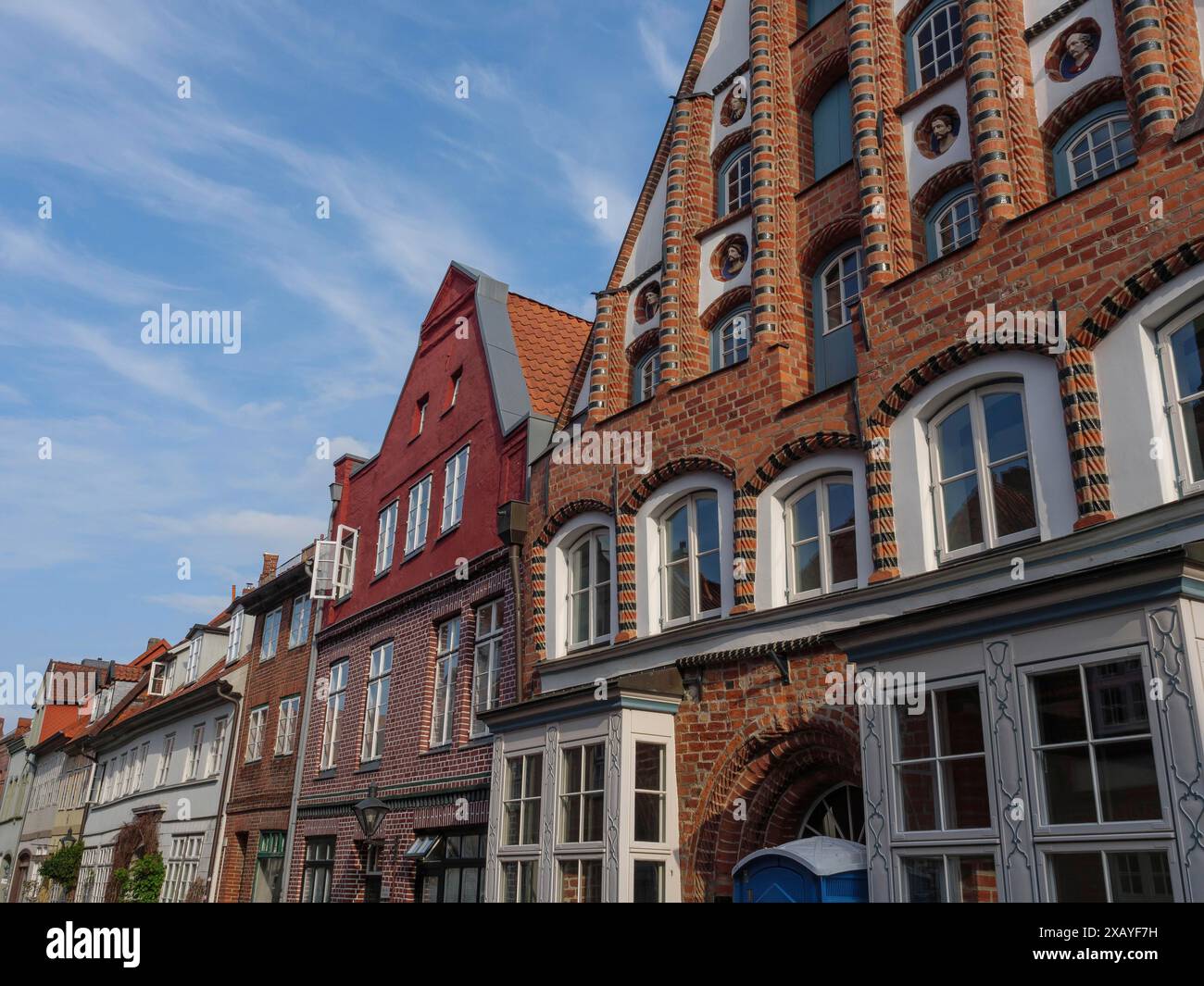 Straßenszene mit historischen Backsteingebäuden unter blauem Himmel, lüneburg, deutschland Stockfoto