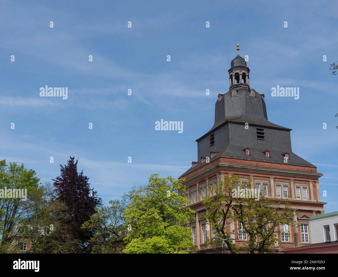 Historisches Gebäude mit Turm und dunklem Dach unter blauem Himmel, trier, deutschland Stockfoto