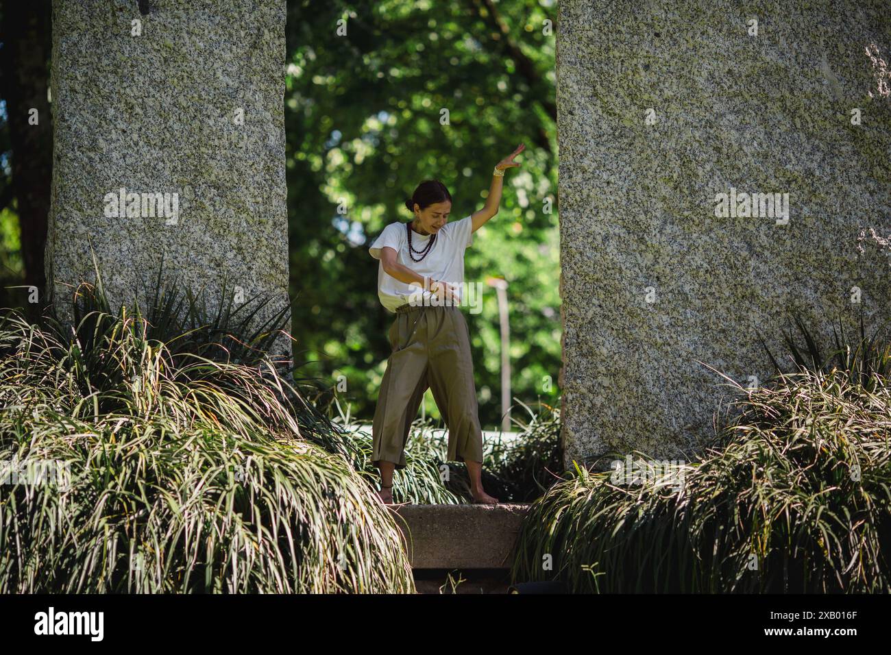 Ein Mädchen, das im Park tanzt, ihre Choreografie und fließende Bewegungen fesseln das Publikum. Stockfoto