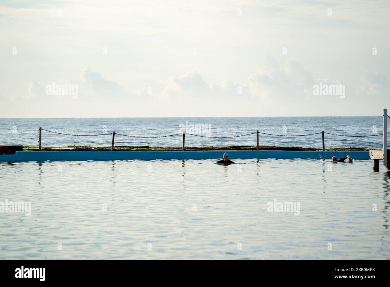 Früh morgens Schwimmer, der in einem Ozeanpool Runden macht Stockfoto