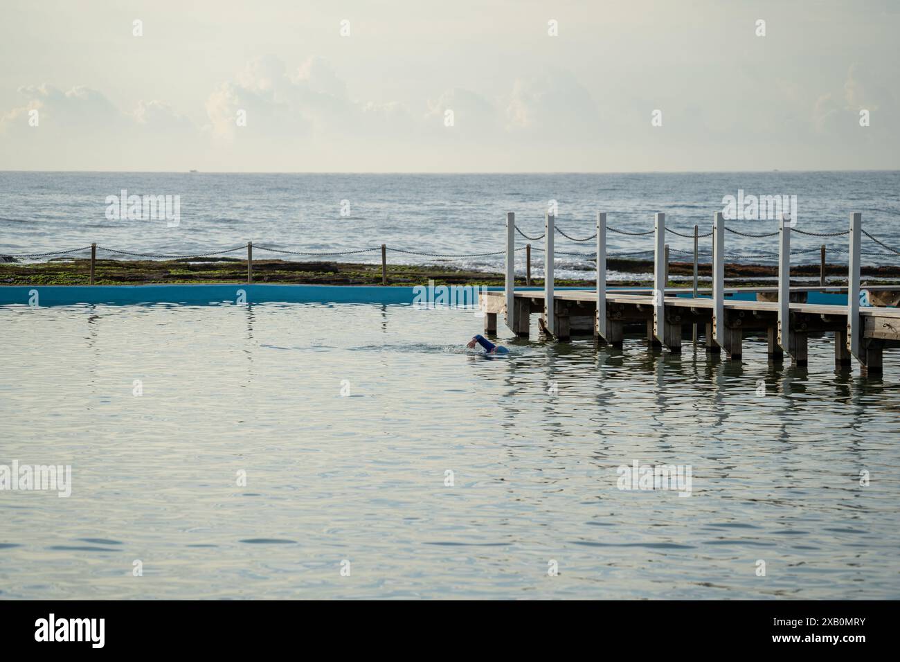 Früh morgens Schwimmer, der in einem Ozeanpool Runden macht Stockfoto