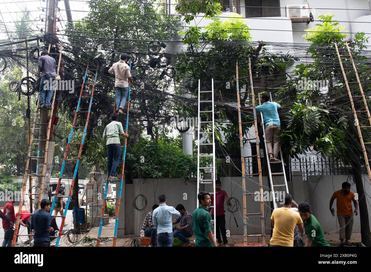 Arbeiter, die durch einen Sturm in Dhaka beschädigte Internet-Kabel reparieren. Bangladesch. Stockfoto