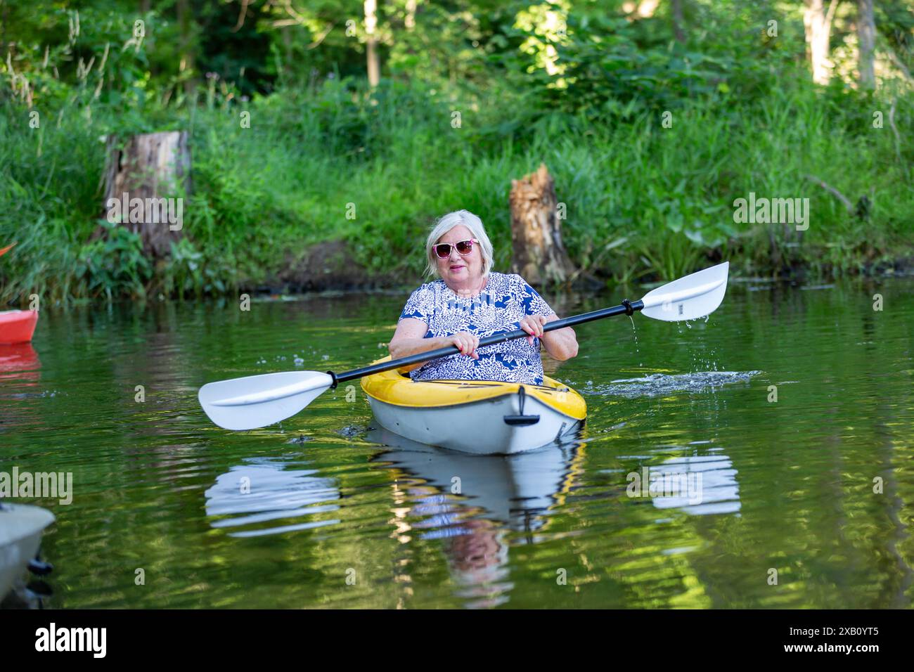 Eine Frau, die auf einem See im Chain O' Lakes State Park in der Nähe von Albion, Indiana, USA, Kajak fährt. Stockfoto