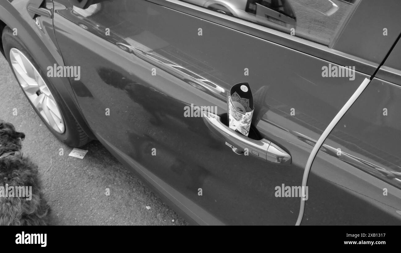 Cremona, Italien - 16. Mai 2024 Schwarzweiß-Foto eines Flyers, der ein indisches Restaurant an einer Autotür anwirbt Stockfoto