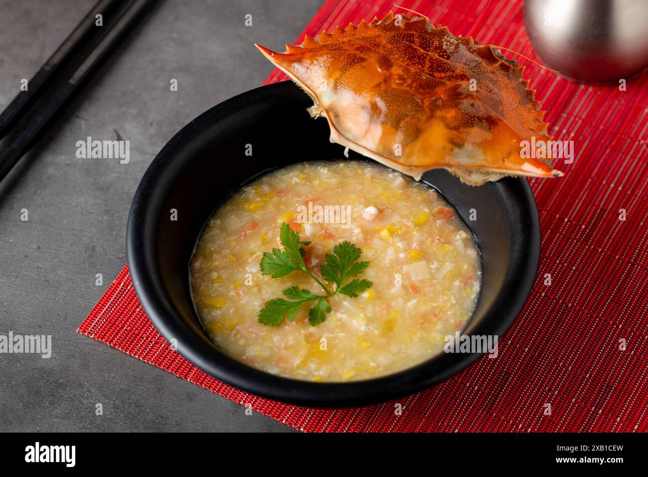 Krabbensuppe auf schwarzem Porzellanteller auf grauem Steintisch Stockfoto