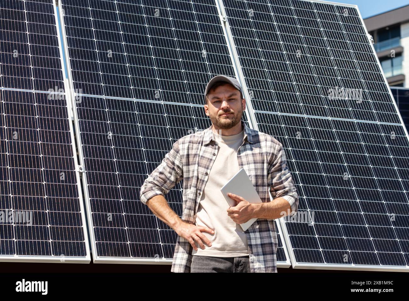 Porträt von der Taille hoch Techniker der Solaranlage überprüft die Wartung von Solarpaneelen in der Stadt. Foreman vor dem Sonnenkollektor draußen. Stockfoto