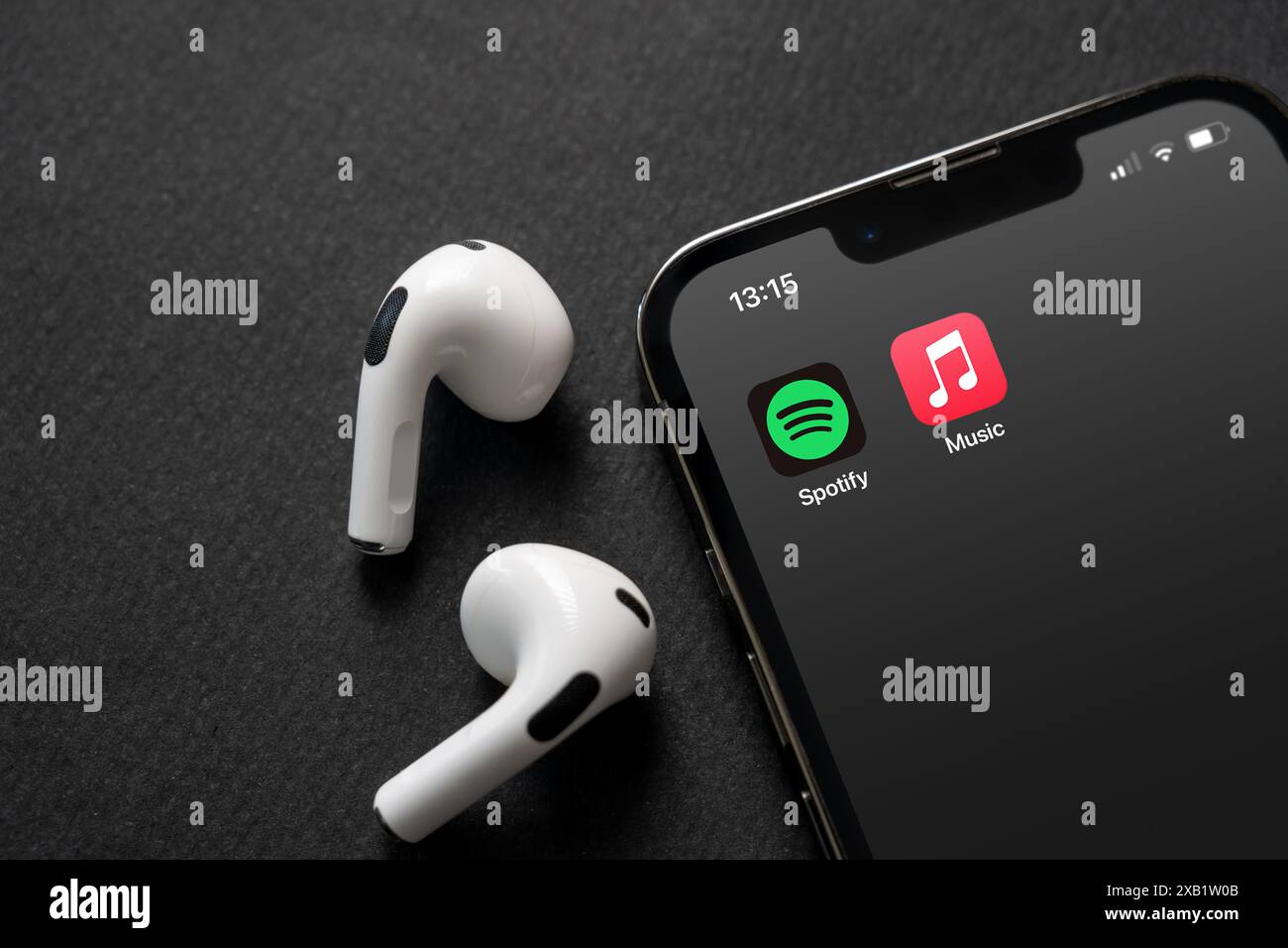 Antalya, Türkei – 5. Juni 2024: Symbole der mobilen App von Spotify und Apple Music auf dem iPhone-Bildschirm mit Airpods daneben Stockfoto
