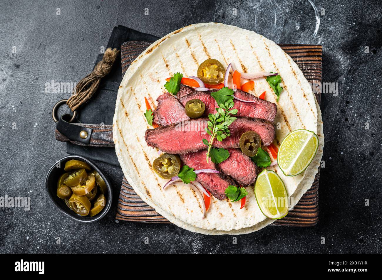 Tacos aus mexikanischem Rindfleisch Fajitas alambre mit Zwiebeln, Jalapeno und Paprika. Schwarzer Hintergrund. Draufsicht. Stockfoto