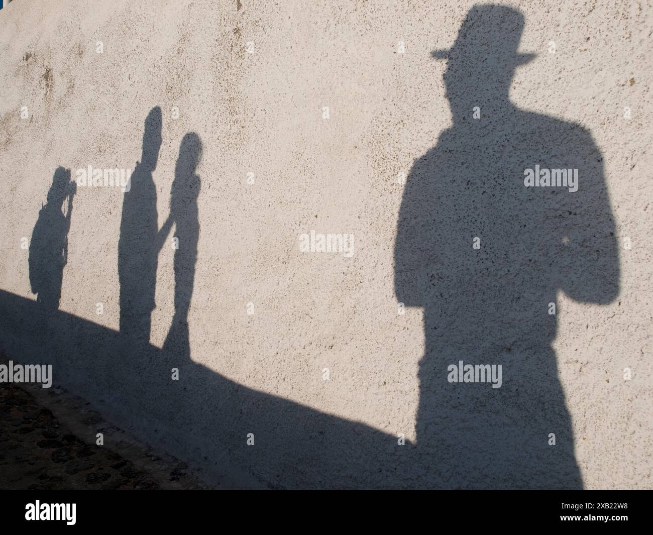 Schatten von Touristen, die in Fira, Santorin, Griechenland spazieren/fotografieren Stockfoto