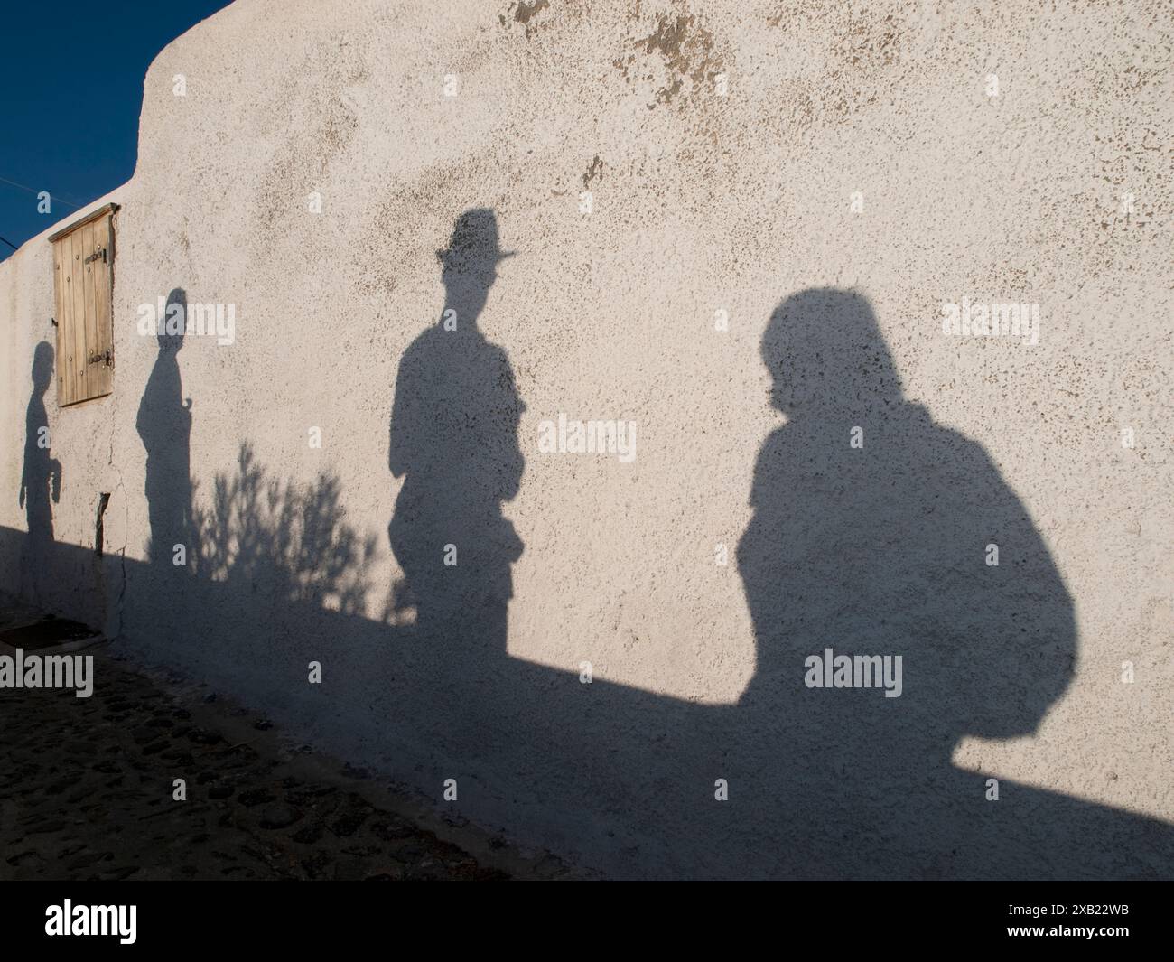 Schatten von Touristen, die in Fira, Santorin, Griechenland spazieren/fotografieren Stockfoto