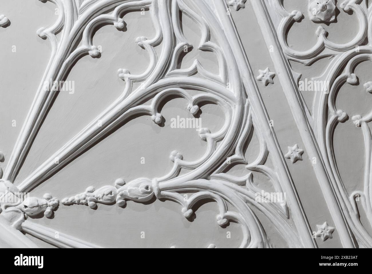 Weiße Gipskarton-Deckenelemente auf grauem Hintergrund. Abstrakte Vorlage in klassischer Architektur, gotischer Stil Stockfoto Weiße Gipskarton-Deckenelemente auf grauem Hintergrund. Abstrakte Vorlage in klassischer Architektur, gotischer Stil Stockfoto