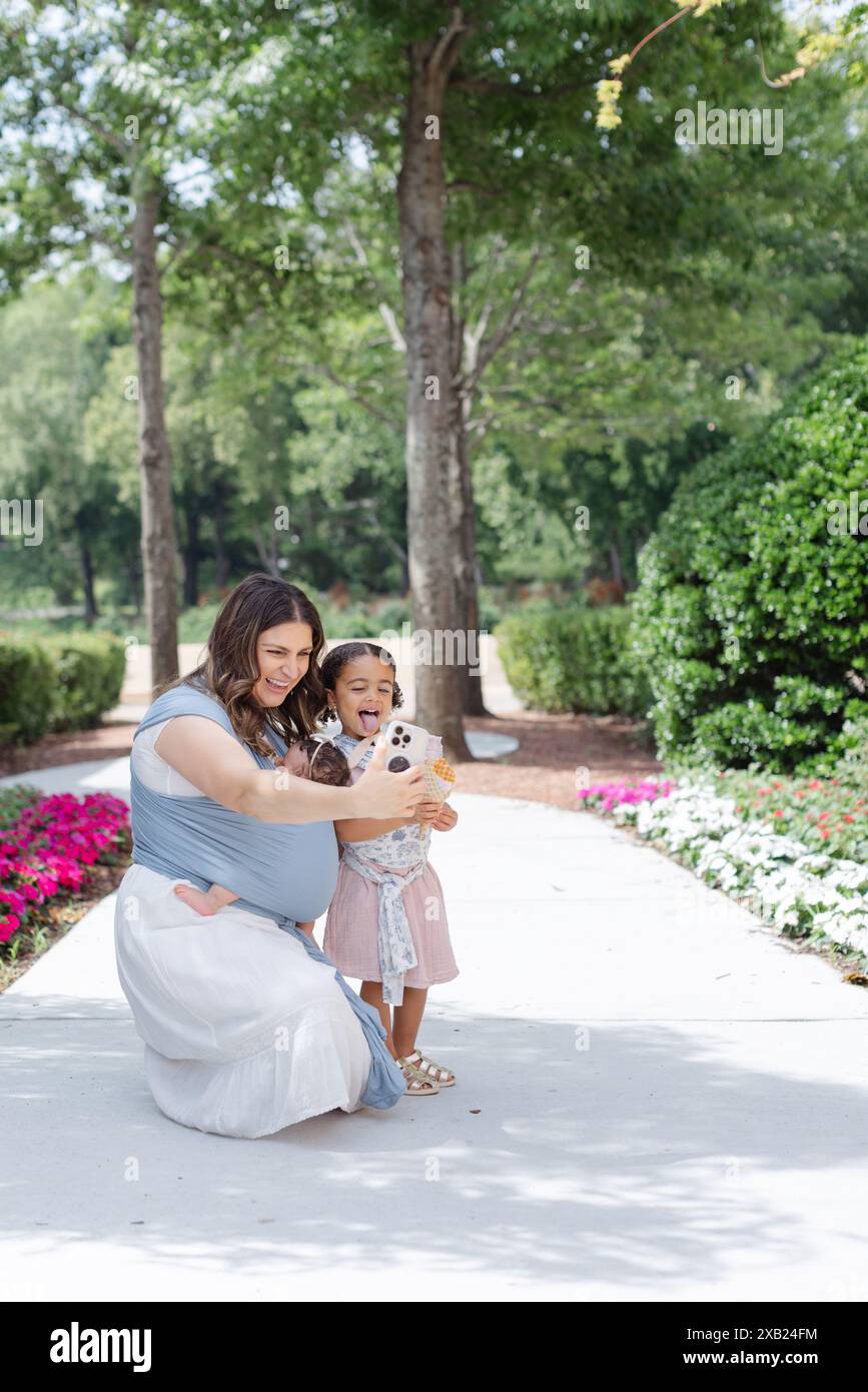 Mom und Tochter machen draußen dumme Gesichter, während sie Selfie machen Stockfoto