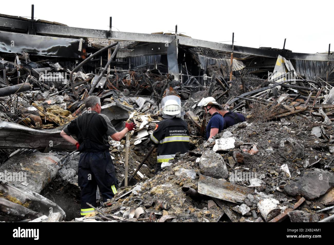 Feuerwehrleute und Rettungskräfte durchsuchten die Trümmer im Epizentrum K Store in Charkiw, nachdem russische UMPB D30-SN-Lenk-Bomben im Mai 2024 das Geschäft getroffen hatten Stockfoto