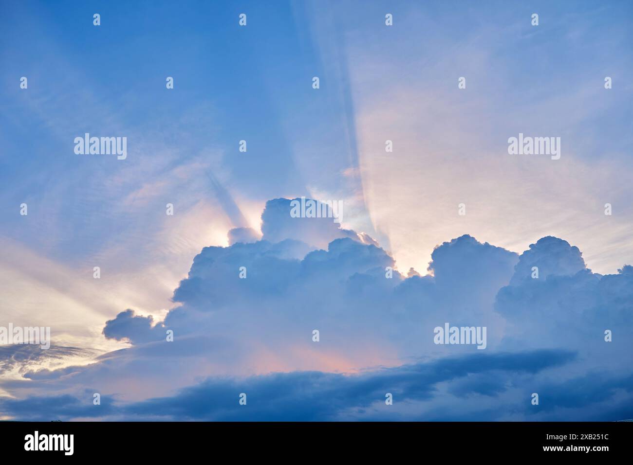 Tiefwinkelansicht des Sonnenlichts, das bei Sonnenuntergang durch Wolken strömt Stockfoto