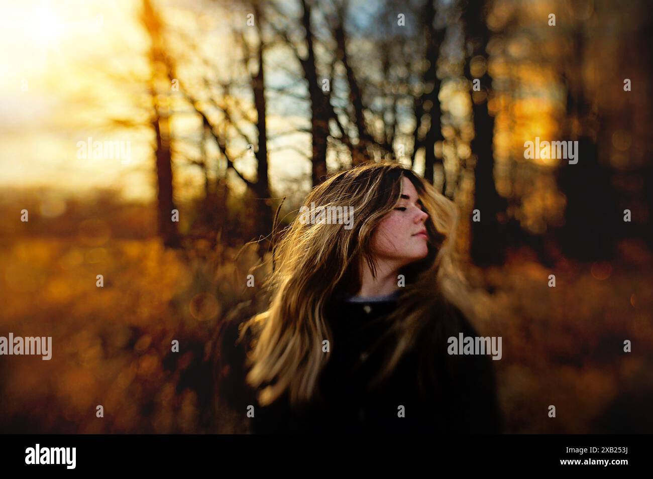 Wunderschöner Teenager, der draußen lange blonde Haare umdreht Stockfoto