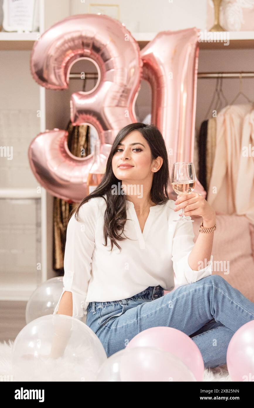 Frauen halten ein Glas Champagner mit einem leichten Lächeln Stockfoto