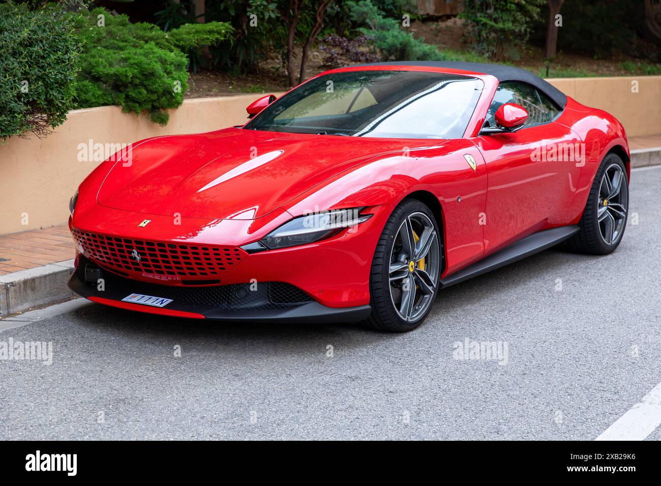 Monte-Carlo, Monaco - 9. Juni 2024: Ein eleganter roter Ferrari Roma Sportwagen parkt auf einer Straße. Das luxuriöse Fahrzeug besticht durch seine leuchtenden Farben und Stockfoto