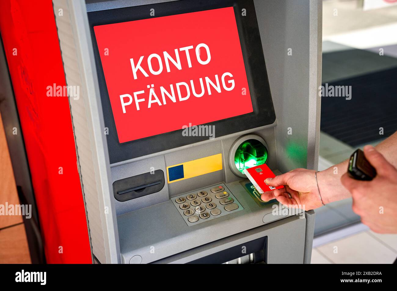 10. Juni 2024: Geldautomat mit der Inschrift: Kontobeschlagnahme. Ein Mann legt eine Debitkarte in den Geldautomaten ein, während die Warnung angezeigt wird. FOTOMONTAGE *** Bankautomat mit Aufschrift: Kontopfändung. Ein Mann steckt eine EC-Karte in den Geldautomat, während die Warnung angezeigt wird. FOTOMONTAGE Stockfoto