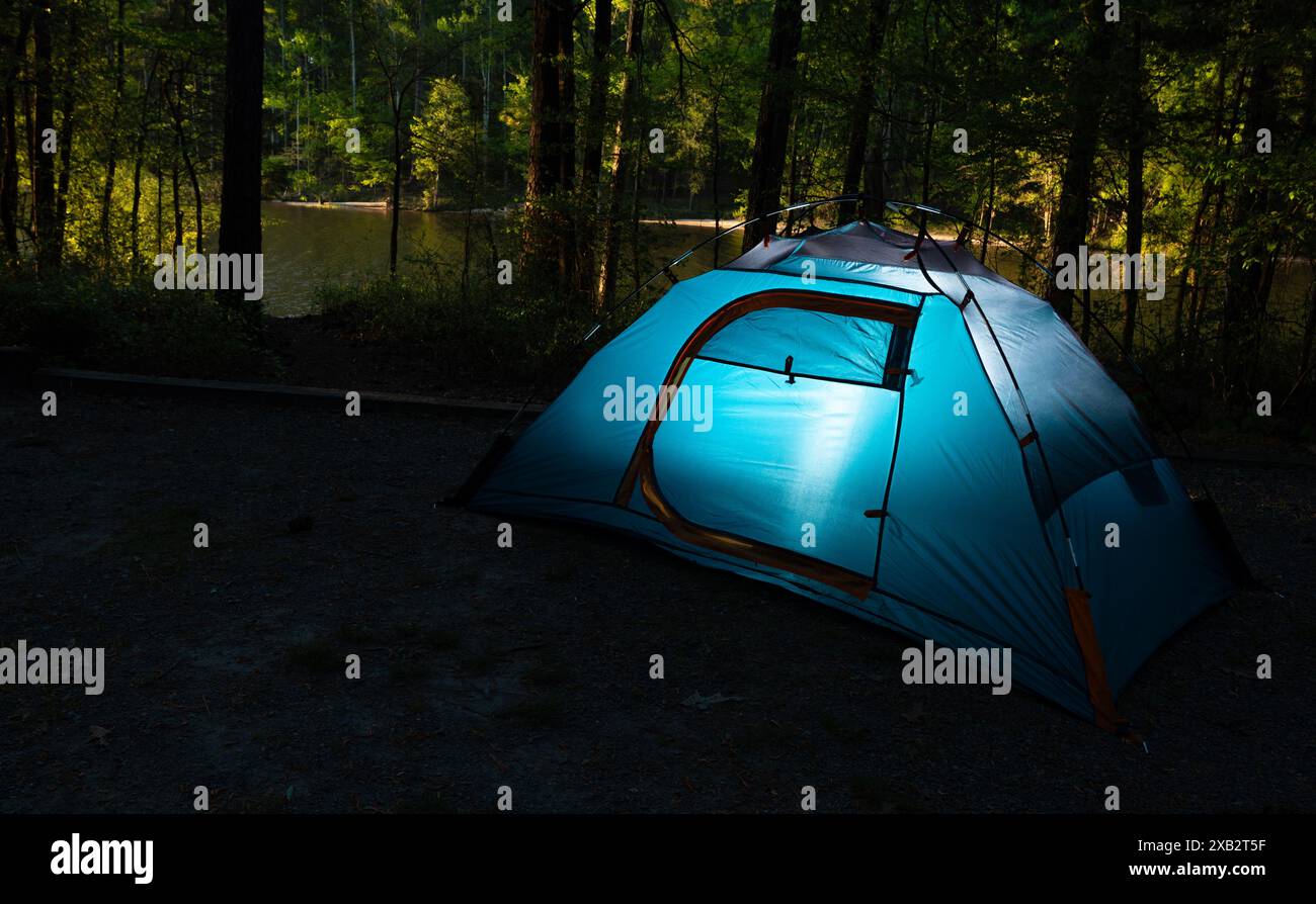 Ein Teil des Outdoor-Lebensstils umfasst oft Rucksacktouren zu abgelegenen Campingplätzen, vor allem in Waldgebieten in der Nähe von Gewässern wie diesem. Stockfoto Ein Teil des Outdoor-Lebensstils umfasst oft Rucksacktouren zu abgelegenen Campingplätzen, vor allem in Waldgebieten in der Nähe von Gewässern wie diesem. Stockfoto