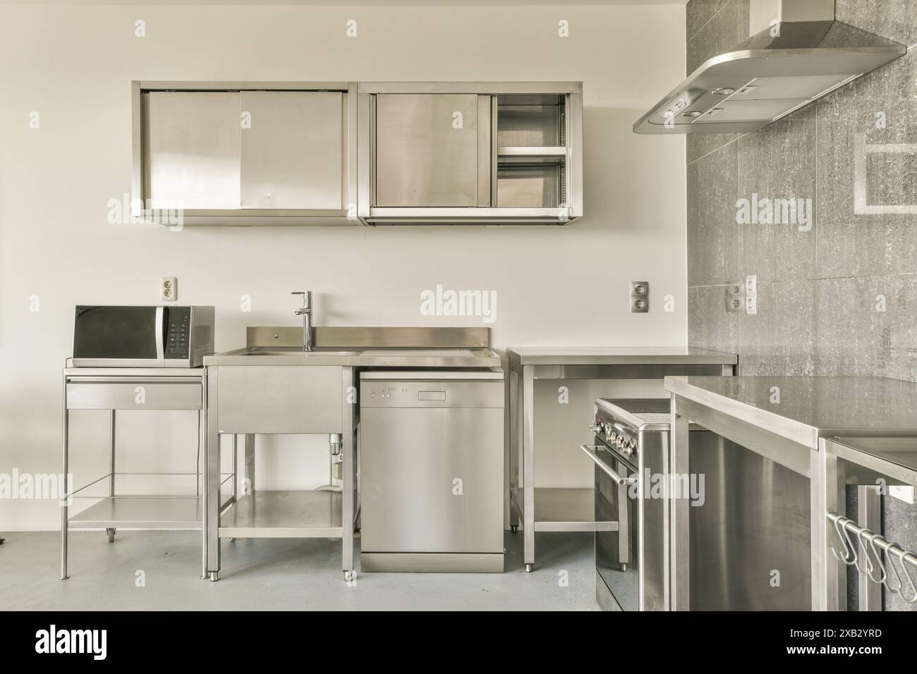 Moderne Küche mit Geräten aus Edelstahl und Einrichtung im Bos en Lommerweg 276. Mit Geschirrspüler, Herd und Mikrowelle Stockfoto