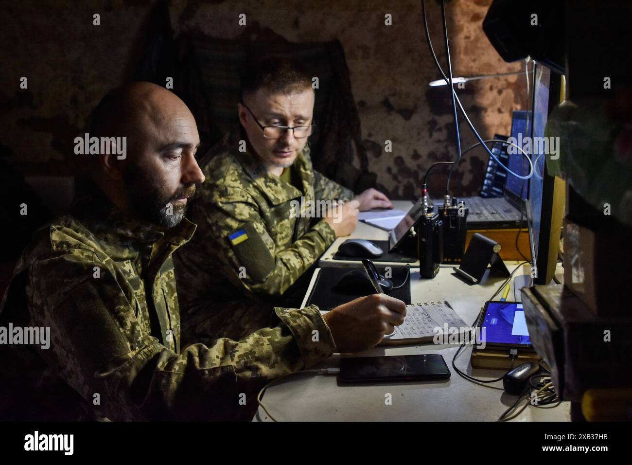 Ukrainische Soldaten der 65. Separaten mechanischen Brigade im Dienst in einem Unterschlupf an der Front in der Region Zaporischschschi. Berichten zufolge ist die von Westen bereitgestellte Artilleriemunition an der Front der ukrainischen Streitkräfte angekommen, wenn auch nicht in einem Ausmaß, das es den ukrainischen Truppen erlauben würde, den derzeitigen Artilleriemusenvorteil des russischen Militärs vollständig herauszufordern. Stockfoto