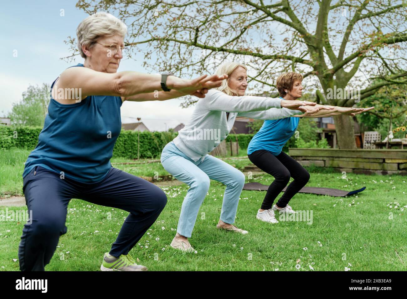 Ältere Frauen in Outdoor-Fitnesskursen, die aktiv in der Natur bleiben, andere dazu inspirieren, das Wohlbefinden zu priorisieren und Freunde in der freien Natur zu genießen Stockfoto