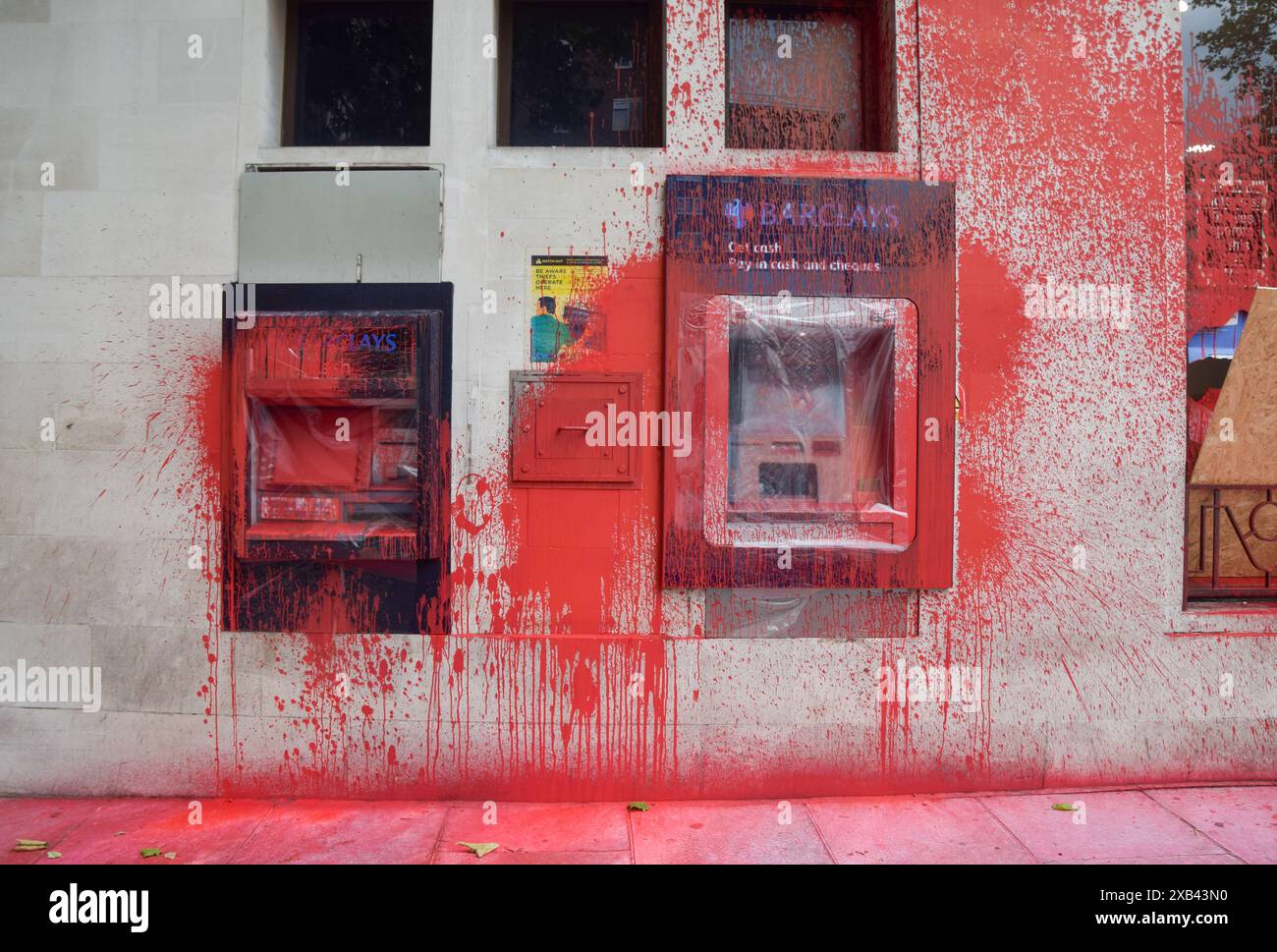 London, Großbritannien. Juni 2024. Geldautomaten an der Barclays Bank in St. John's Wood sind mit roter Farbe bedeckt und beschädigt. Aktivisten der Gruppe Palestine Action zertrümmerten Fenster und spritzten rote Farbe auf mehrere Zweige von Barclays und forderten von der Bank den Verkauf von israelischen Waffen. Quelle: SOPA Images Limited/Alamy Live News Stockfoto