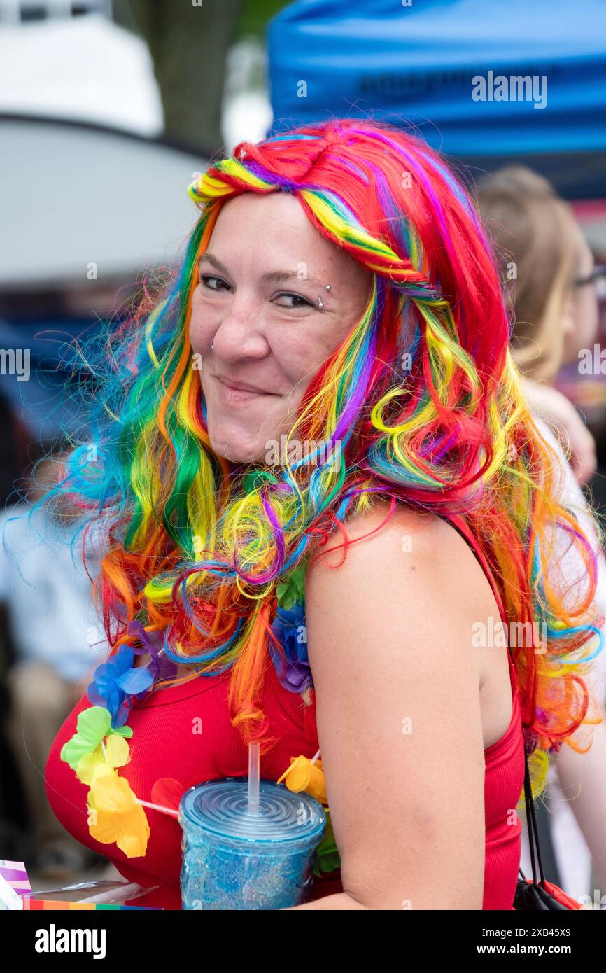 Eine Frau mit einer mehrfarbigen Perücke bei der City of Poughkeepsie Pride Parade 2024 im Waryas Park. Stockfoto