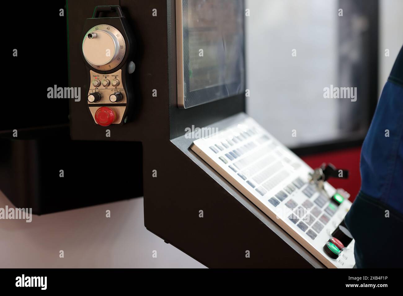 CNC-Steuertafel des industriellen Bearbeitungszentrums mit Handfernbedienung in Nahaufnahme. Selektiver Fokus. Stockfoto