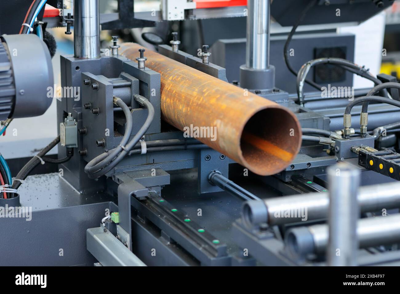 Schneiden von Metallrohren auf einer automatischen horizontalen Bandsäge. Selektiver Fokus. Stockfoto