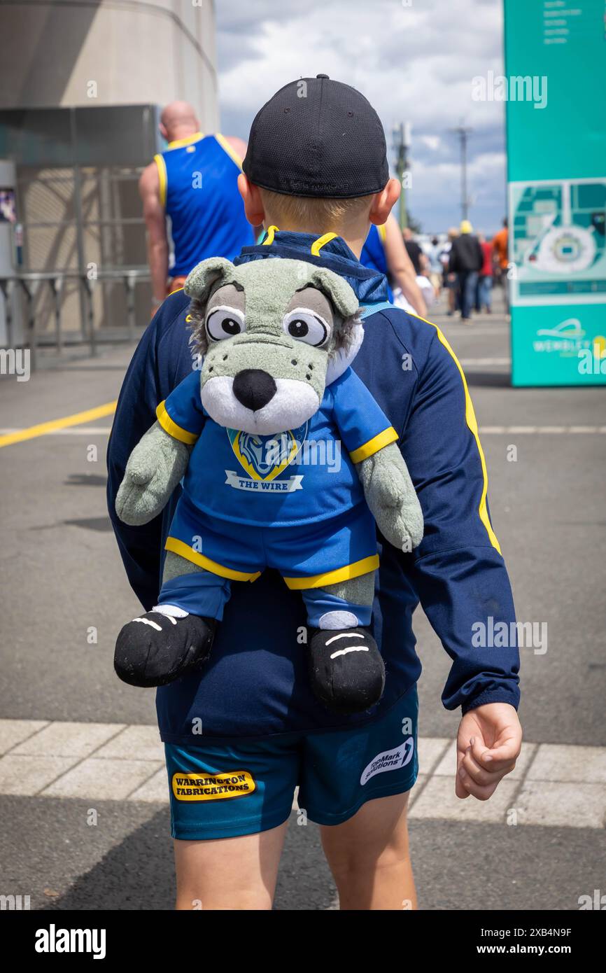 Das Finale des Betfred Challenge Cup 2024 in Wembley zwischen Warrington und Wigan. Kleiner Junge, der einen "Wolfie"-Rucksack vor dem Stadion trägt Stockfoto