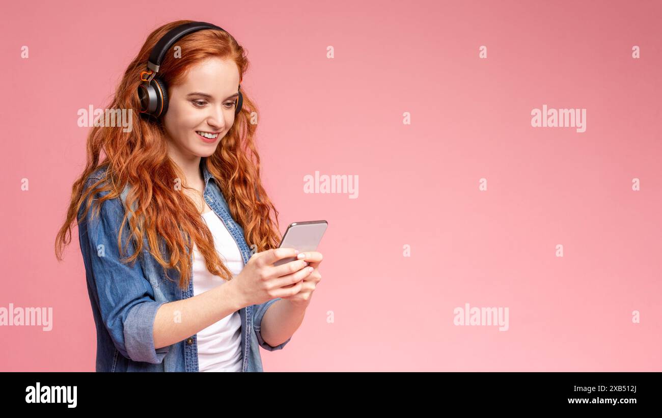 Frau, die Kopfhörer trägt und ihr Telefon ansieht Stockfoto